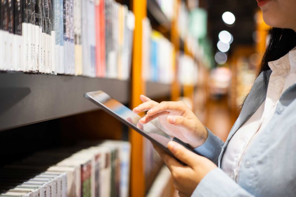 Women using digital tablet in library